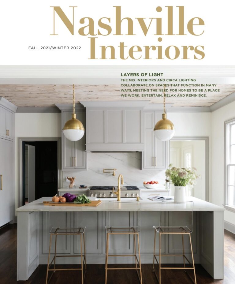 Modern kitchen with gray cabinets, marble backsplash, and gold pendant lights © Nashville Interiors