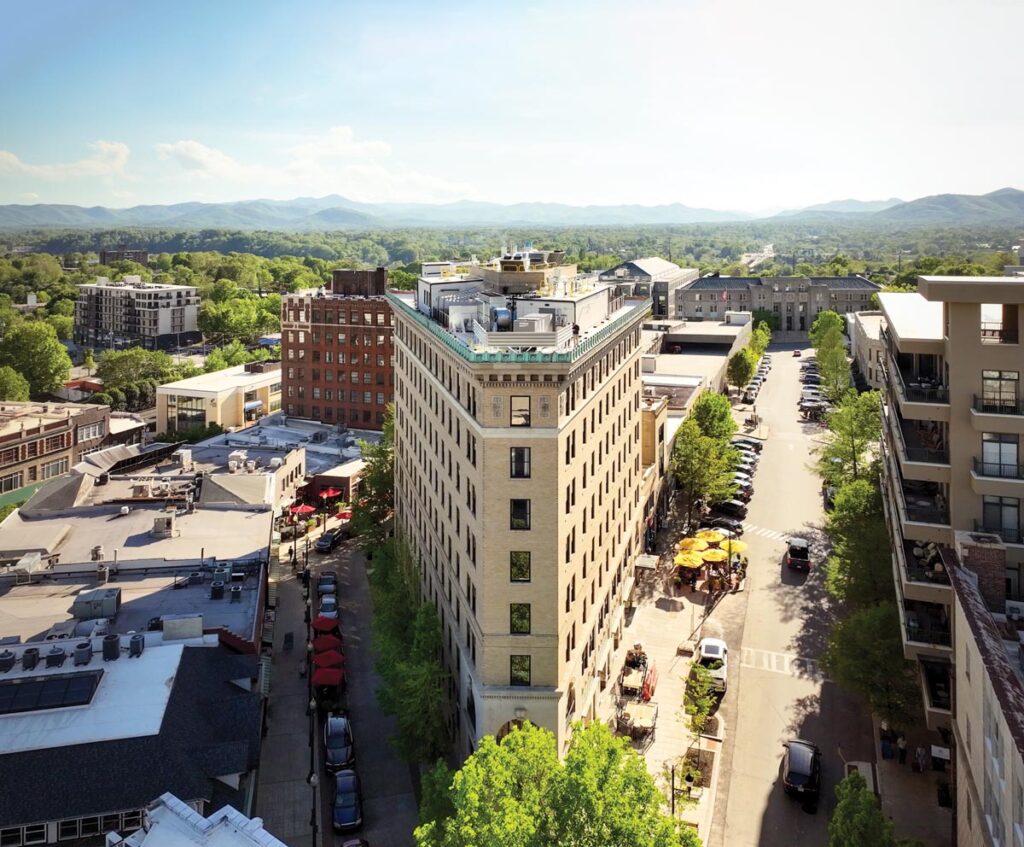 Aerial view of historic Flatiron Building in Asheville with surrounding cityscape and mountains © Nashville Interiors