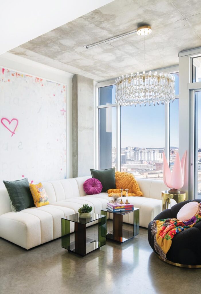Modern living room with white couch and glass table in bright apartment © Nashville Interiors