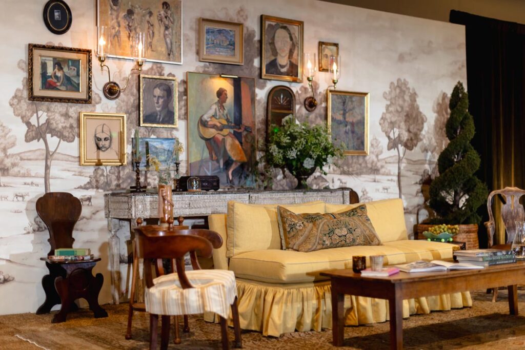 Vintage living room with yellow couch, gallery wall, and antique furniture © Nashville Interiors