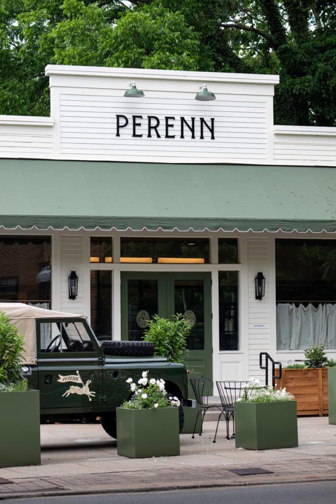 Charming storefront of Perenn with green awning and vintage vehicle