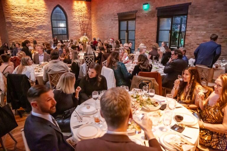 Guests enjoying a formal dinner in an elegant, warmly lit venue Photo by Nashville Interiors
