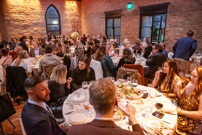 Guests enjoying a formal dinner in an elegant, warmly lit venue Photo by Nashville Interiors