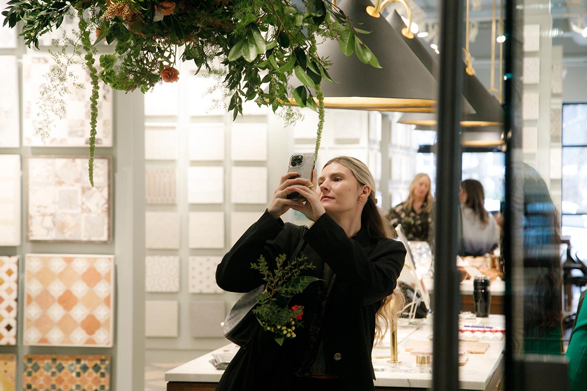 Woman photographing floral decor in modern interior store Photo by Nashville Interiors