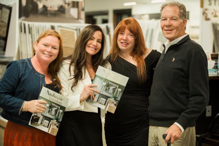 Four people holding Nashville Interiors magazine at an event Photo by Nashville Interiors
