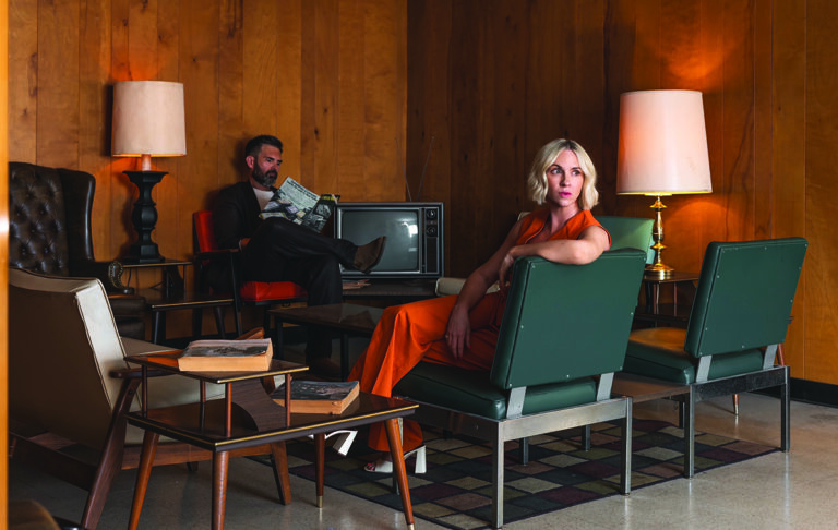 Retro lounge with vintage furniture and a couple in stylish attire Photo by Nashville Interiors