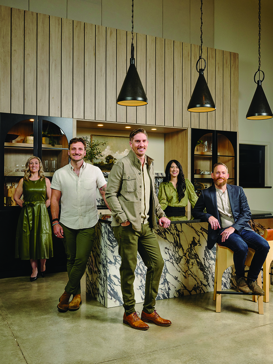 Five people in stylish attire posing in a modern kitchen setting Photo by Nashville Interiors