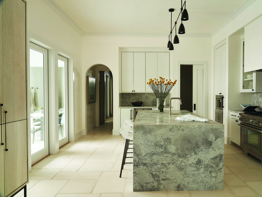 Modern kitchen with marble island and pendant lighting Photo by Nashville Interiors
