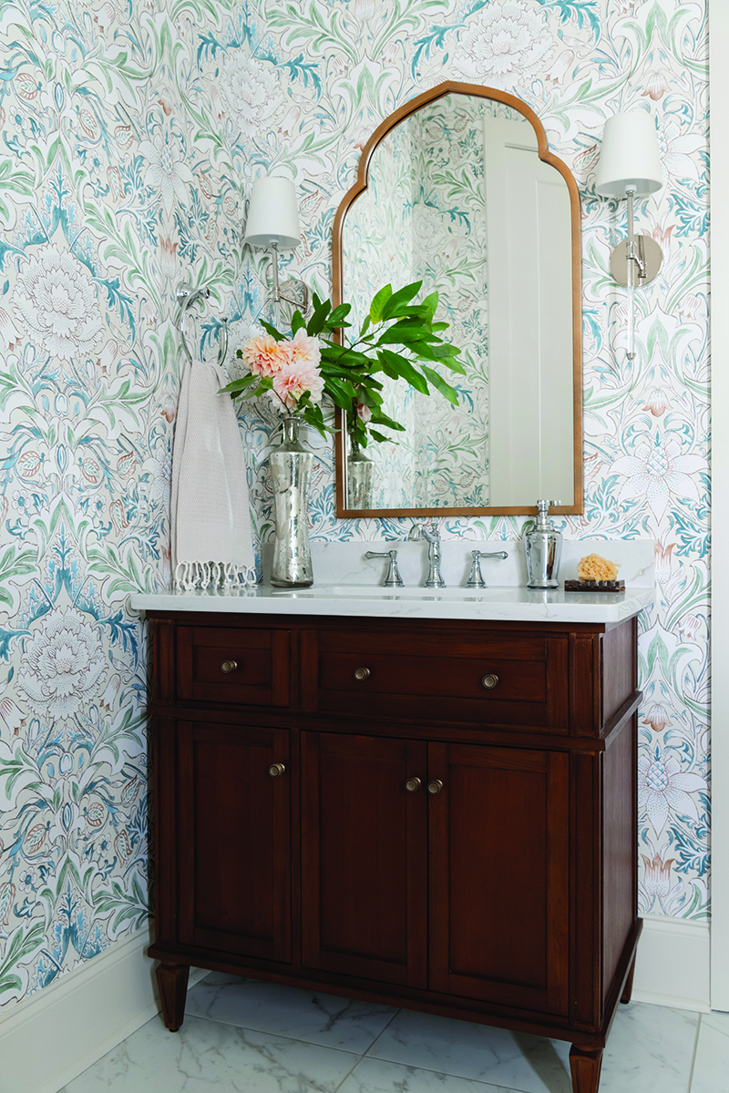Elegant bathroom with floral wallpaper and wooden vanity with marble countertop Photo by Nashville Interiors