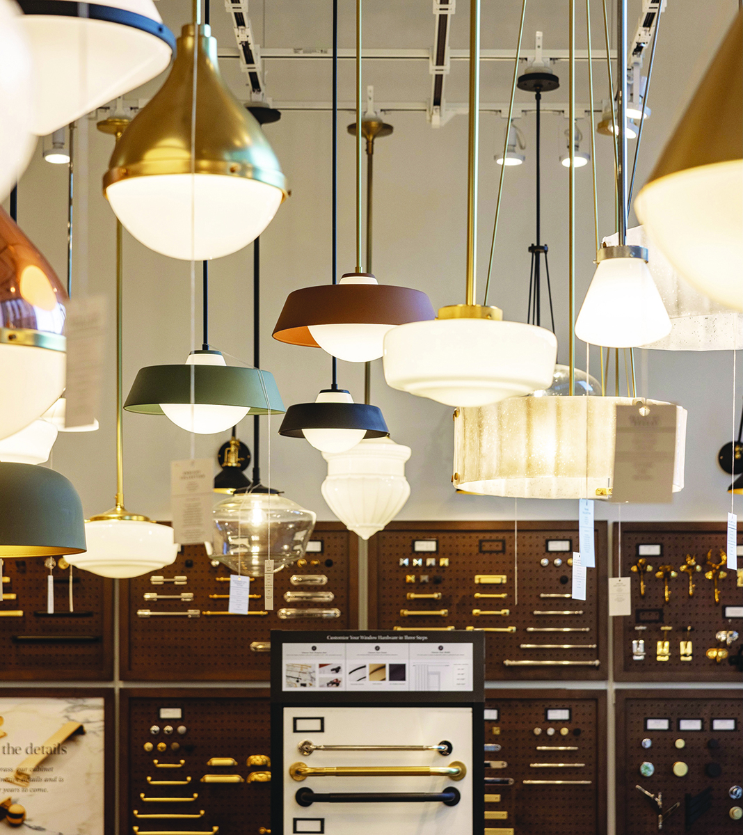 Various modern pendant lights in a showroom with hardware display Photo by Nashville Interiors