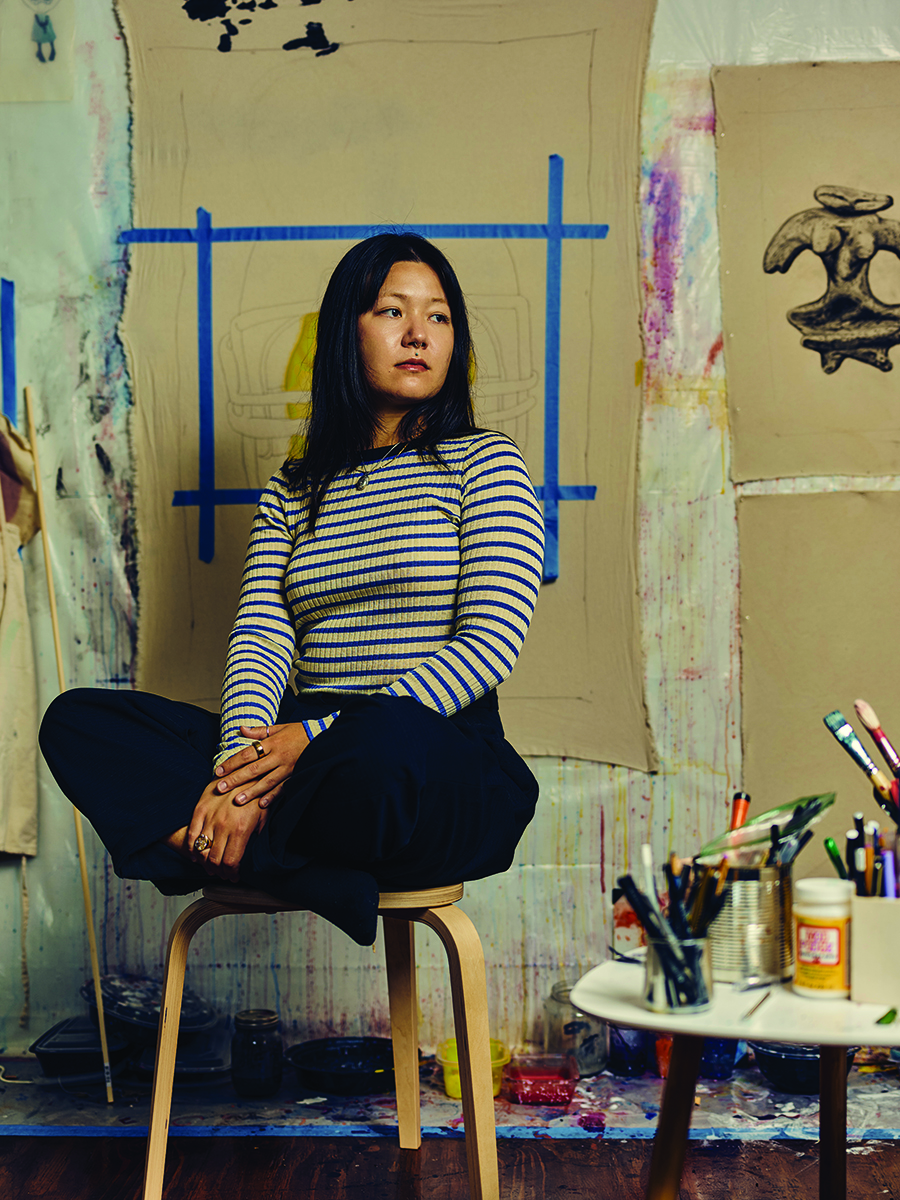 Artist sitting in studio surrounded by sketches and painting tools Photo by Nashville Interiors