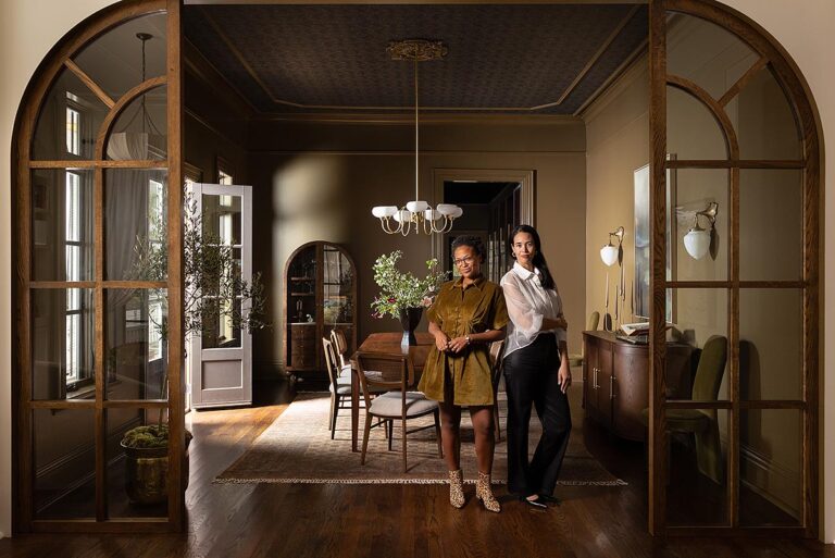 Elegant dining room with arched wooden doors and two women standing - Nashville Interiors